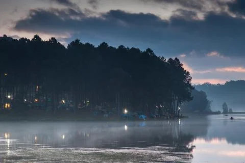 Water in dam with mountain reflection under cloudy sky Stock Photos
