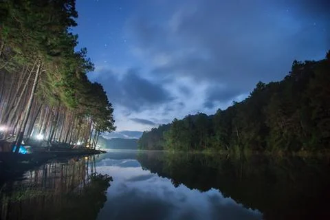 Water in dam with mountain reflection under cloudy sky Stock Photos