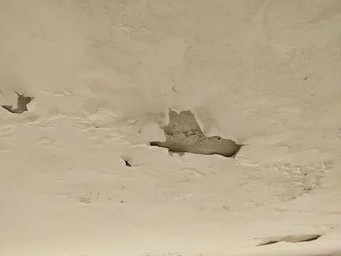 Water damage to a ceiling, characterized by paint peeling, bubbling, and flaking Stock Photos
