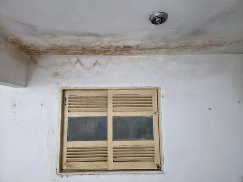 Water damaged ceiling and wall above an old window Stock Photos