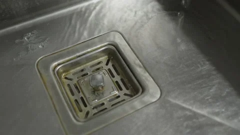 Water down a sink drain. Streaming water in sink. Stock Footage 232294960