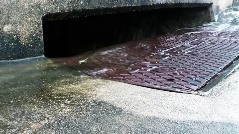 Water down the storm drain in the rain 02 1080 fast Stock Footage 77656711
