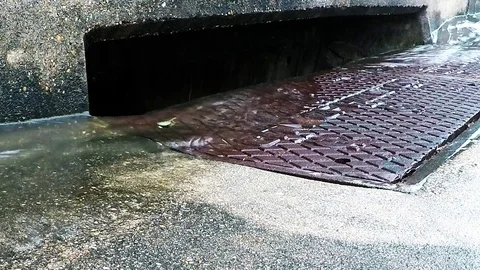 Water down the storm drain in the rain 02 1080 slow Stock Footage 77656779