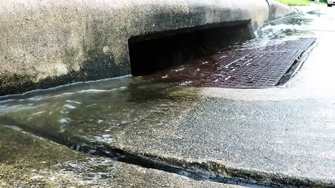 Water down the storm drain in the rain 1080 slow Stock Footage 77656807