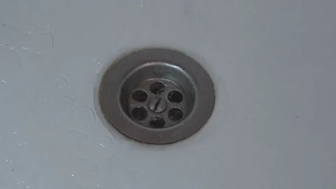 Water drain down on stainless white steel kitchen sink hole Stock Footage 168634241