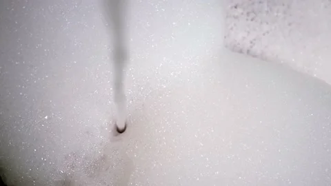 Water drawn into bubble bath, close-up of jet water from the faucet in bathroom Stock Footage 239261508