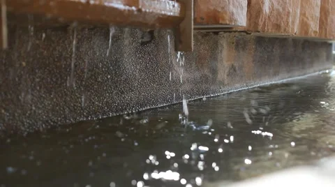 Water dripping off cement into a puddle Stock Footage 2727490