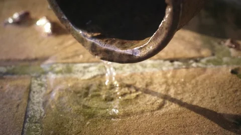 Water dripping down by the gutter. rain water streaming on the ground, natural  Stock Footage 166947466