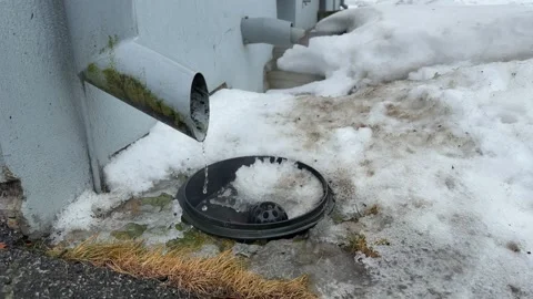 Water dripping from drain pipe and steam from heating outlet winter exterior Stock Footage 331593075