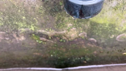Water dripping from a drain pipe in a ditch Stock Footage 274048636