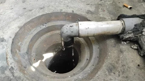 Water dripping from a drain pipe in a ditch Stock Footage 279128571