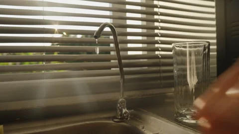 Water Dripping from Filter Faucet While Hand Turns the Valve to Tightly Close It Stock Footage 308453785