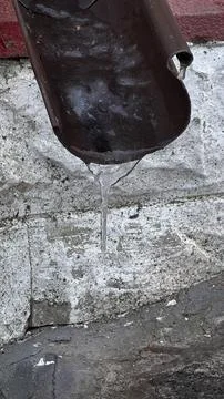 Water Dripping from Gutter in Urban Setting Stock Photos