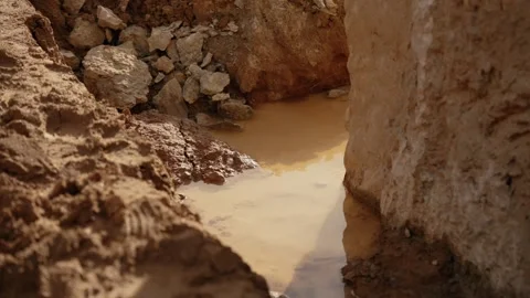 Water dripping into a muddy puddle after rain Stock Footage 341294587