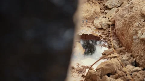 Water dripping into a muddy puddle in a trench Stock Footage 341294533