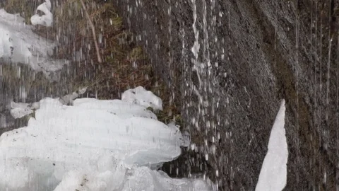 Water dripping onto snow and ice on a wa... | Stock Video | Pond5