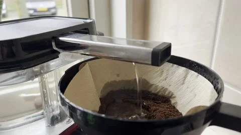 Water dripping through ground coffee beans to brew coffee coffee filter machine Stock Footage 233221759