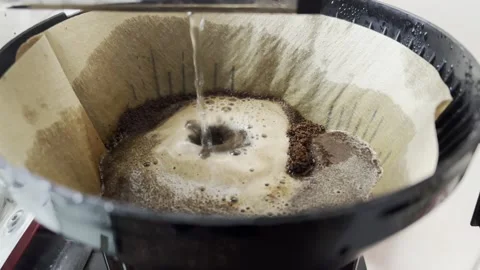 Water dripping through ground coffee beans to brew coffee coffee filter machine Stock Footage 233221762