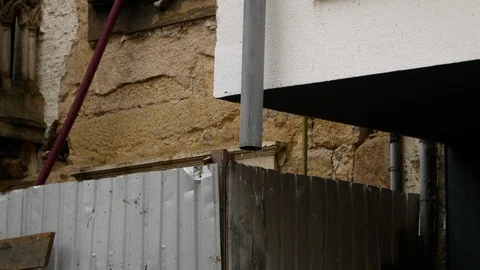 Water drips from drainage pipe on construction site of old building Stock Footage 104266862