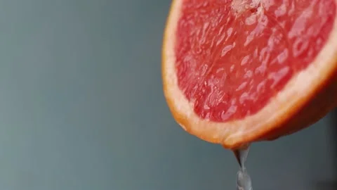 Water drips from half a grapefruit. Stock Footage 154647518