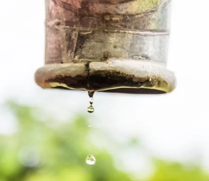 Water drips from a pipe. Stock Photos