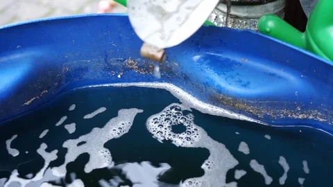 Water drips from a rain gutter into a water barrel 2 Stock Footage 119442740