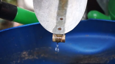 Water drips from a rain gutter into a water barrel 3 Stock Footage 119442795