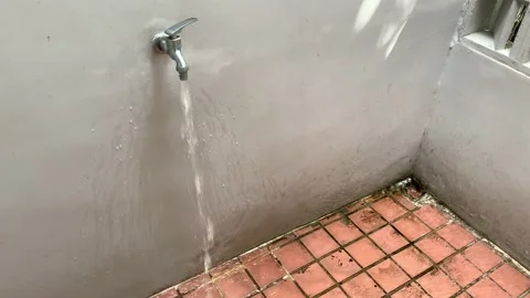 Water drips onto square tile floor Stock Footage 165676372