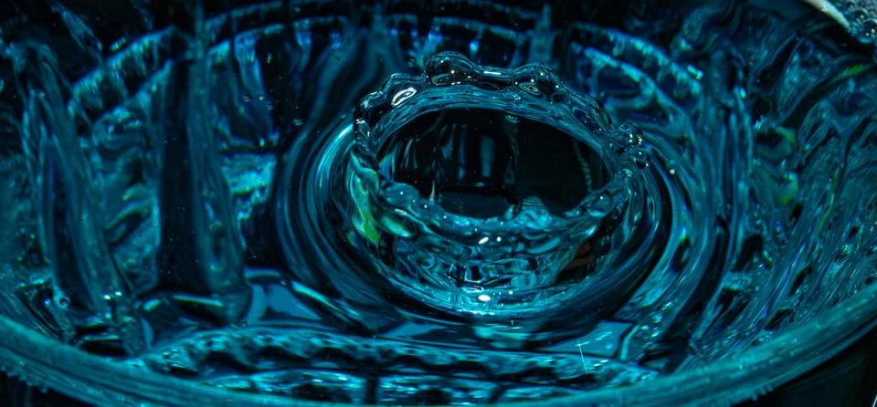 Water drop closeup while drops falling down and splashing into water in Jena Stock Photos