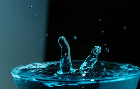 Water drop closeups while drops falling down and splashing into water in Jena Stock Photos