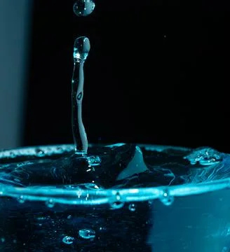 Water drop closeups while drops falling down and splashing into water in Jena Stock Photos