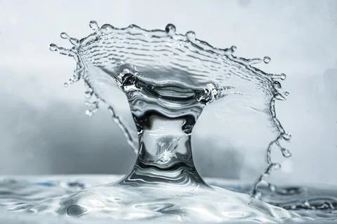 Water drop colliding creating a unique bright water crown, bright background Stock Photos