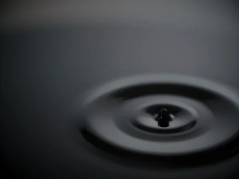 Water drop drips to liquid surface 4k slow-motion video nature dark background Stock Footage 83143366