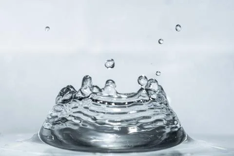 Water drop fall into the liquid, creating a beautiful crown sculpture effect Stock Photos
