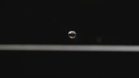 Water drop falling down to water surface Stock Footage 107945683