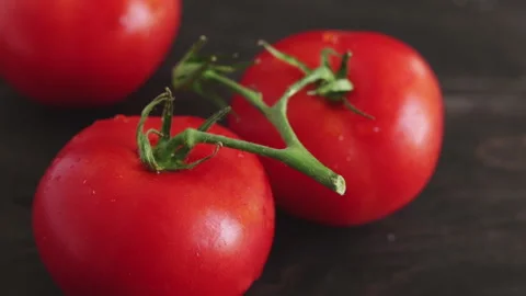 Water drop falling on fresh tomatoes close up footage Stock Footage 102332573