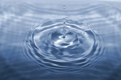 Water drop falling making droplet splash and waves clean and fresh concept Stock Photos