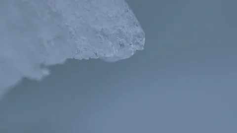 Water drop falling from melting piece of ice Video stock 104925956