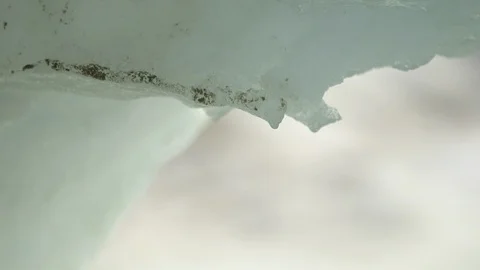 Water drop falling from melting piece of ice Video stock 104951300