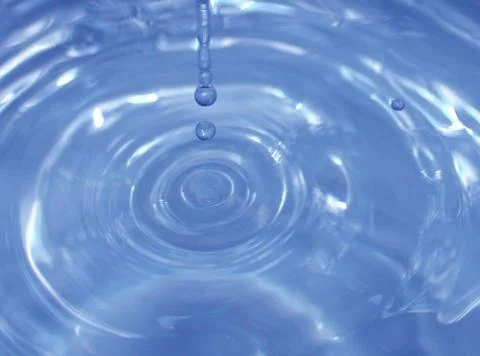 Water drop falling into water making a perfect droplet splash Stock Photos