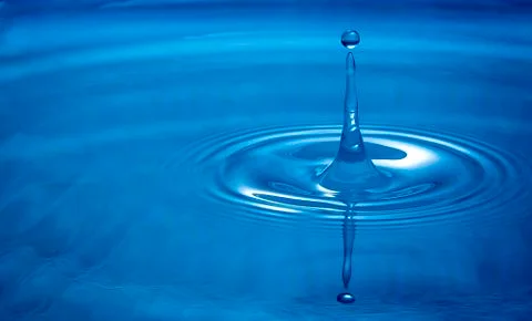 Water drop falling into water Stock Photos