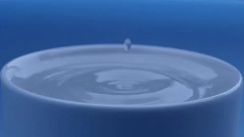 Water drop falls into the filled cup on blue background in slow motion. Stock Footage 142884911