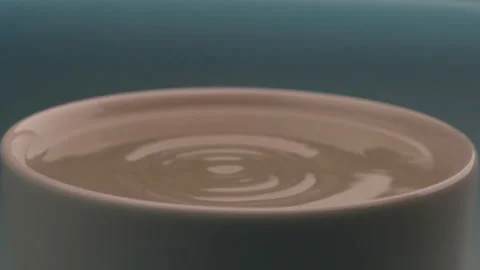 Water drop falls into the filled cup in slow motion. Stock Footage 142884973