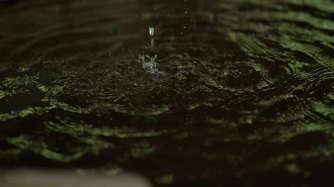 Water Drop Splash Creating Ripples in Dark Fountain Pool Stock Footage 342762620