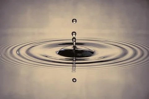 Water drop splash in a gray-colored shot of water that is dripping and refl.. Stock Photos