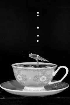 Water Drop Splashes To Create Shapes In A Tea Cup Stock Photos