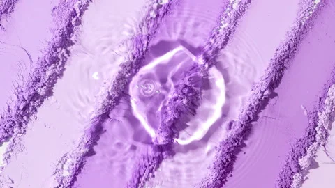Water droplet creating ripple patterns on violet powder Stock Footage 343048758