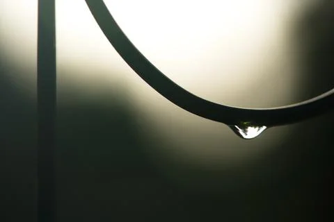Water droplet hanging from wire decoration silhouette Stock Photos