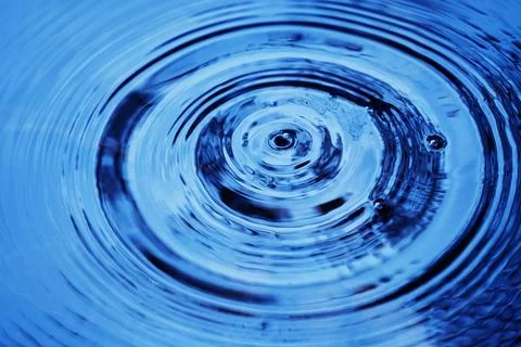 Water droplets affect the surface, forming rings on the surface. 스톡 사진