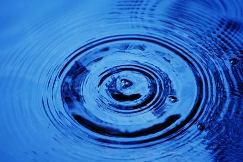 Water droplets affect the surface, forming rings on the surface. 스톡 사진